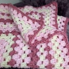 Granny square crochet blanket in a mix of pinks 