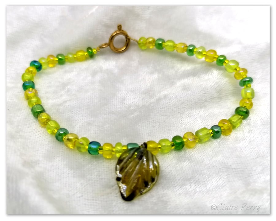 Seed bead bracelet with green coloured glass beads with a green glass charm.
