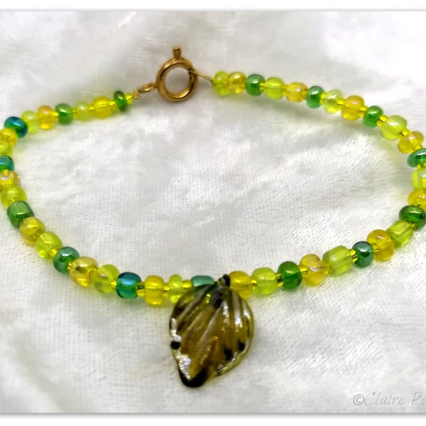 Seed bead bracelet with green coloured glass beads with a green glass charm.