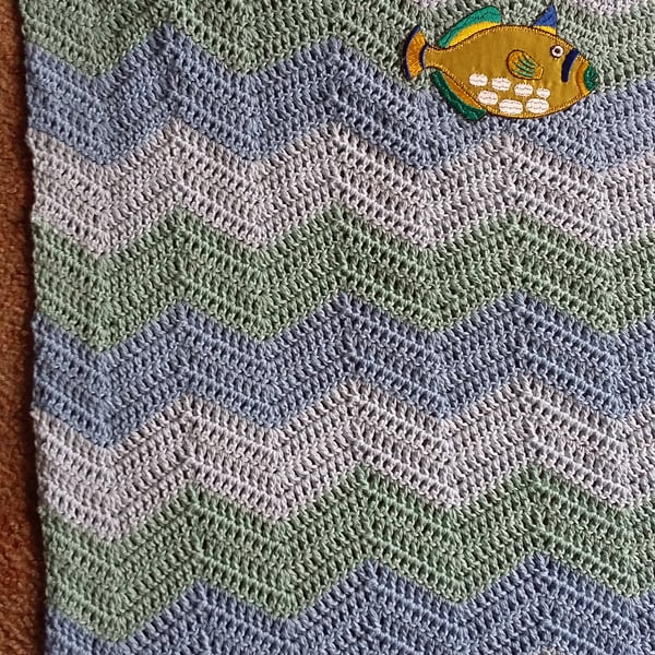 Crochet baby blanket in wavy stripes with applique fish