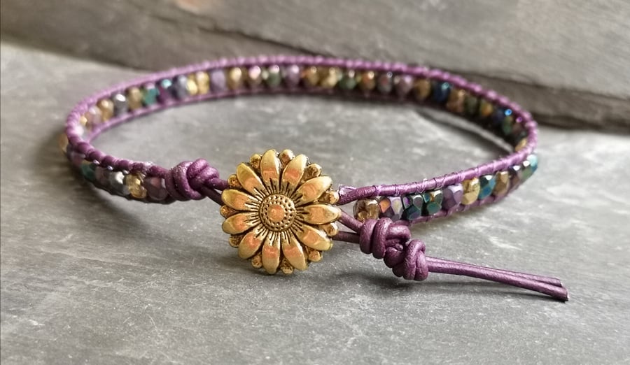 Purple leather bracelet with gold flower button and metallic finish glass beads