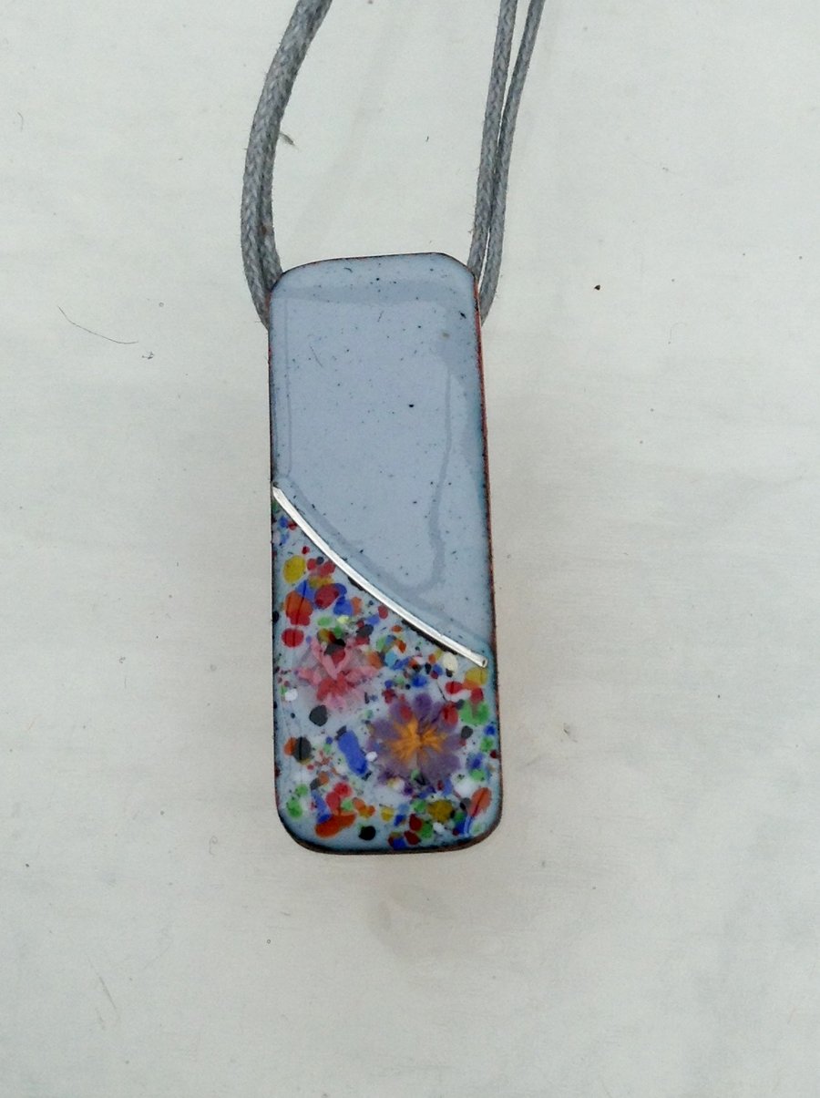 SMALL, SLIM, OBLONG FLORAL ENAMELLED PENDANT WITH STERLING SILVER DESIGN