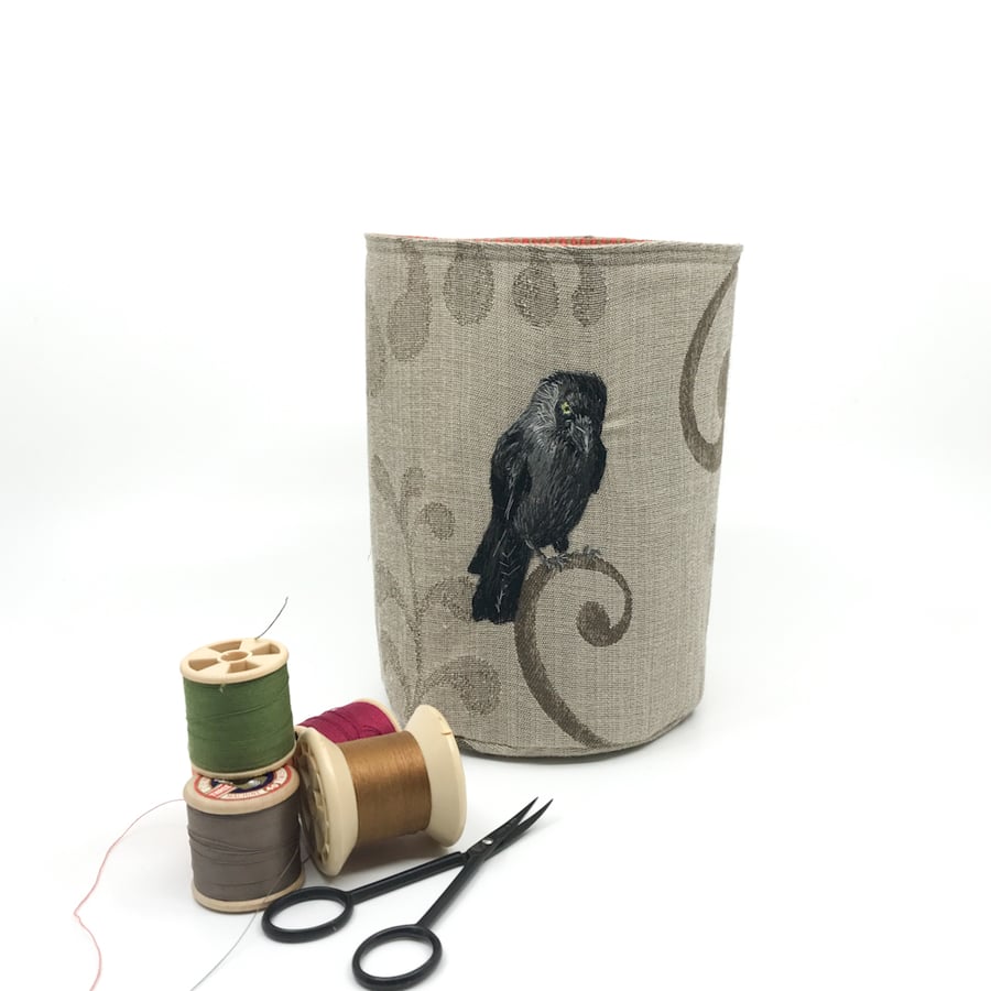 Textile storage pot with embroidered crow