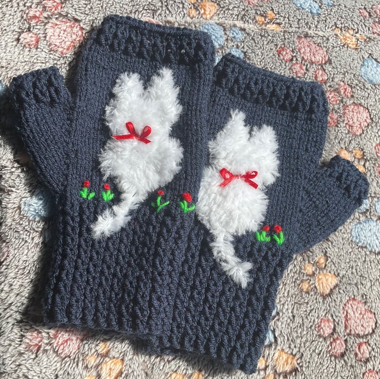 Navy blue mittens with a cat on and added flower embroidery