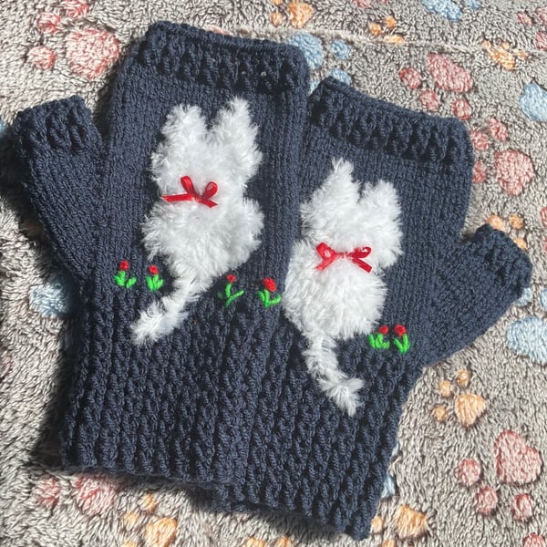 Navy blue mittens with a cat on and added flower embroidery