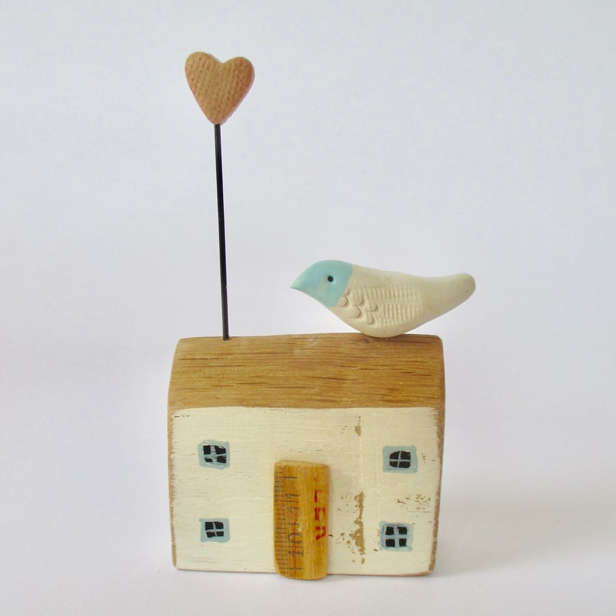 Little wooden house with a clay bird and heart