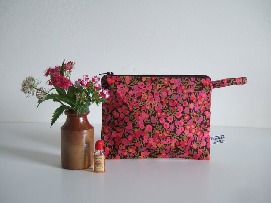 A purse for headphones, make up, or coins made in pink floral Liberty fabric
