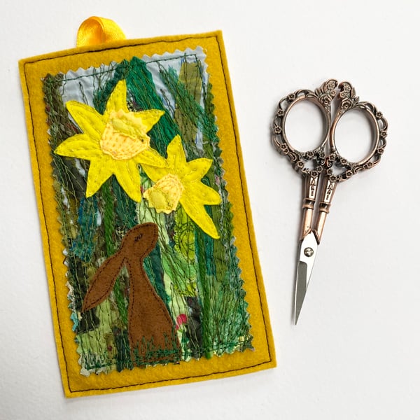 Upcycled embroidered spring rabbit and daffodil home decoration. 