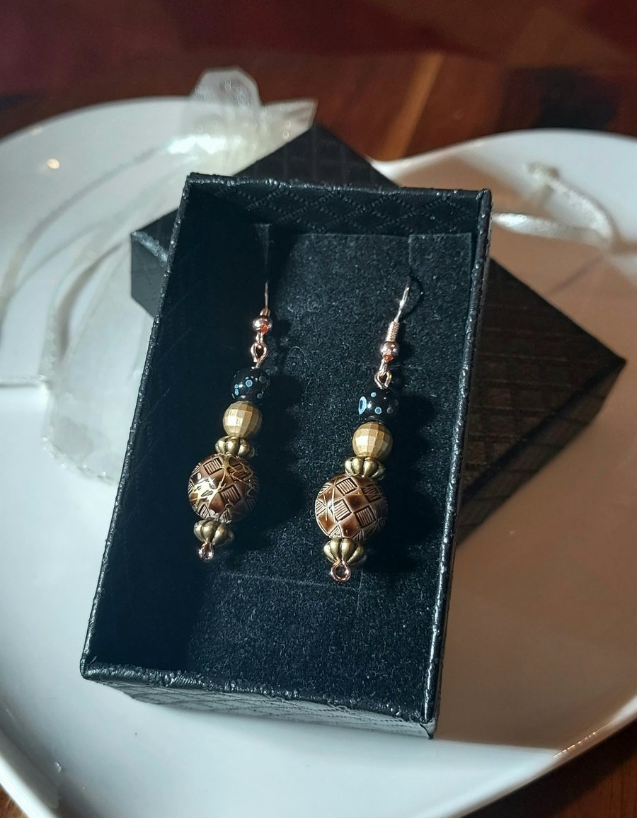 Hypoallergenic beaded earrings in brown and gold tones.
