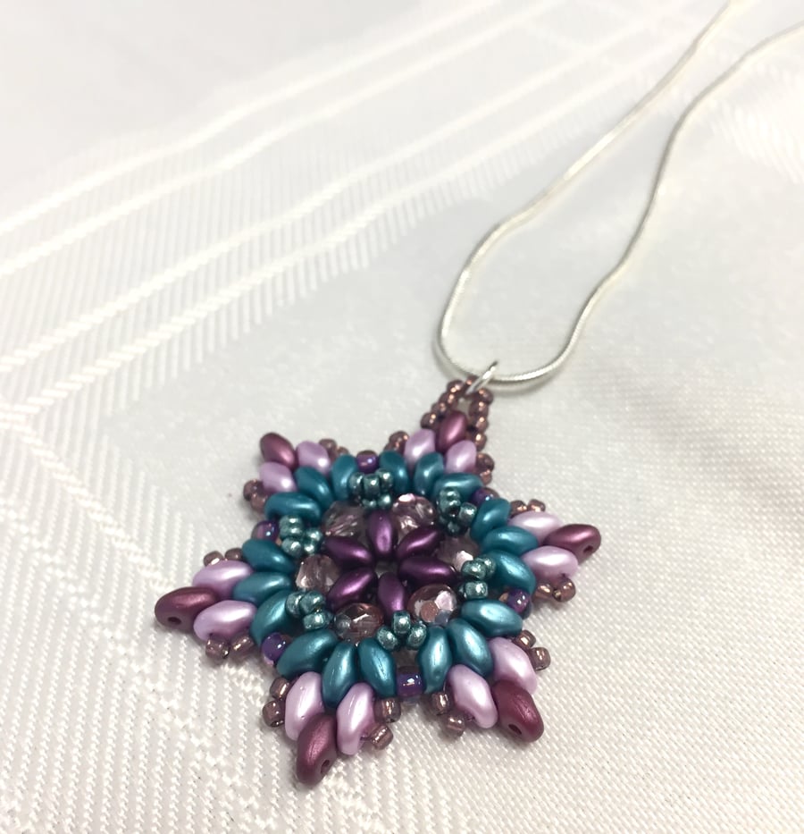 Hand beaded snowflake or flower pendant in lilac, magenta and teal