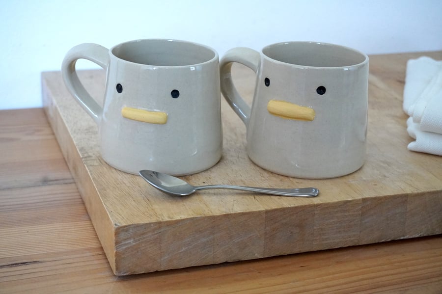 One hand thrown pottery mug with duck face on the front glazed in transparent