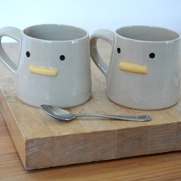 One hand thrown pottery mug with duck face on the front glazed in transparent