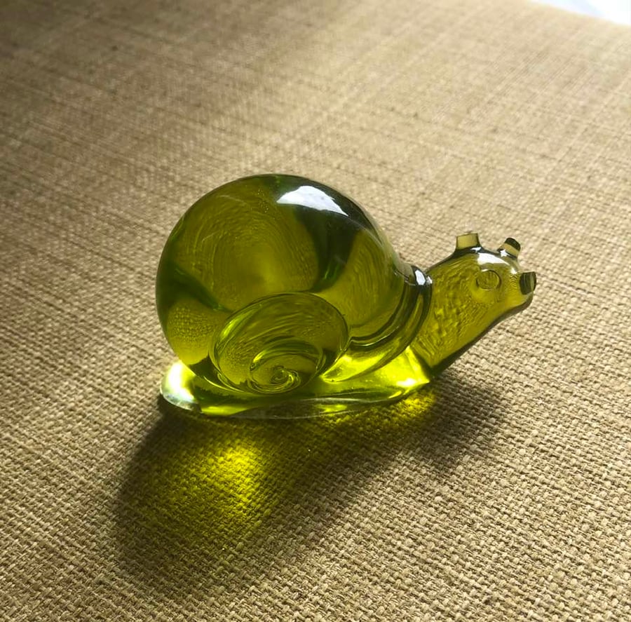 Clear olive green epoxy snail ornament.