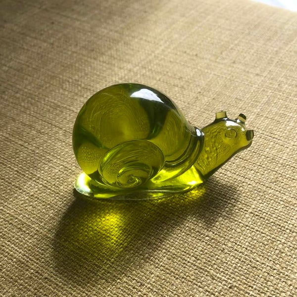 Clear olive green epoxy snail ornament.