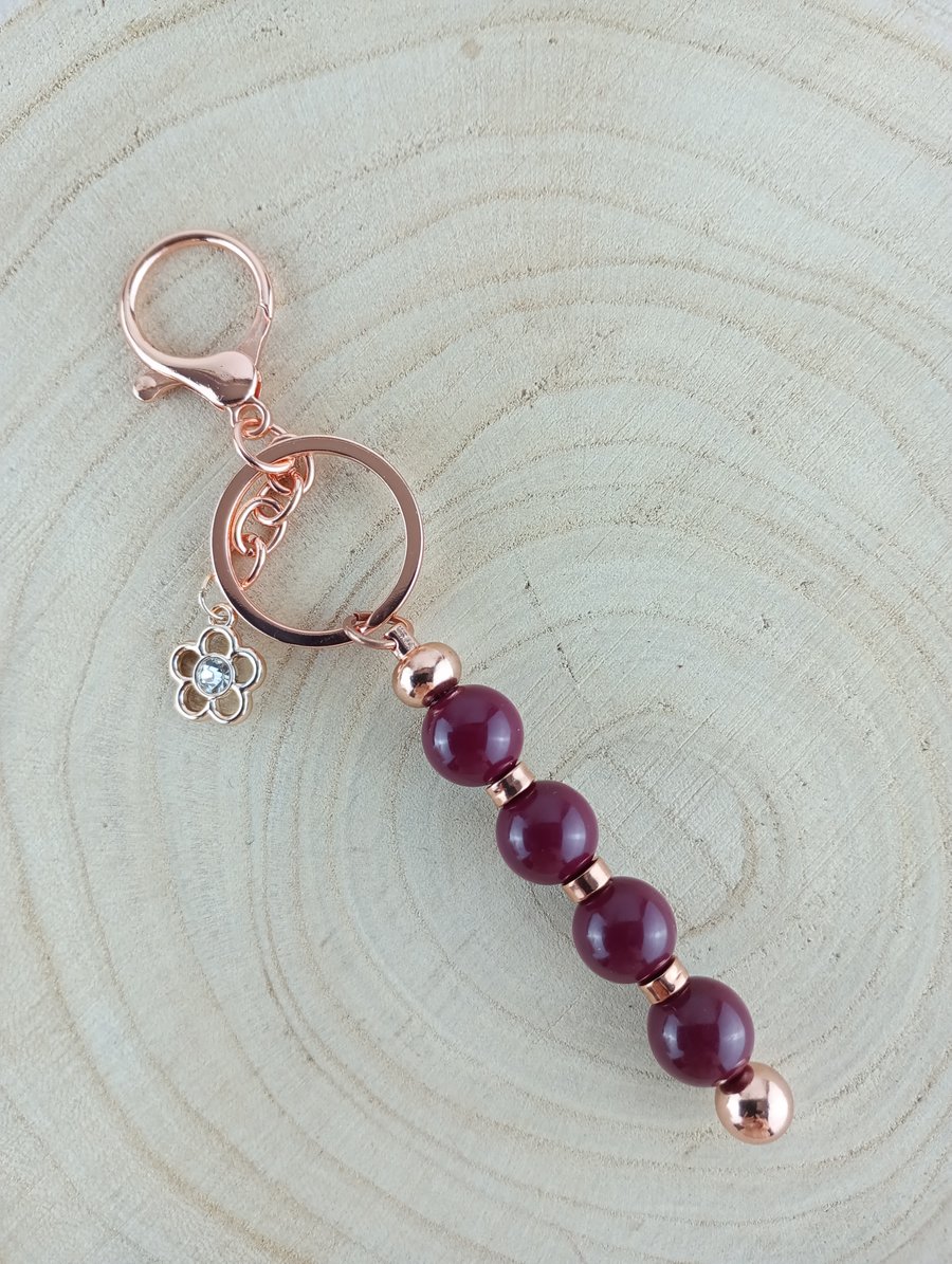 Burgundy beaded keyring with a rhinestone flower charm 