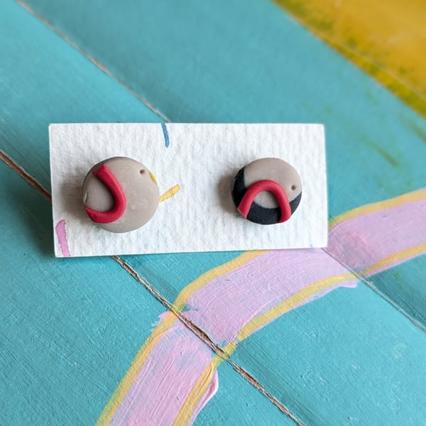 Grey, navy and red stud earrings. 