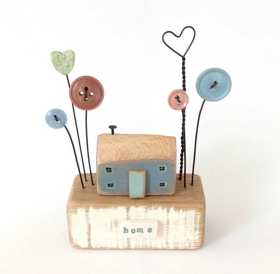Wooden painted house with button flower and heart garden