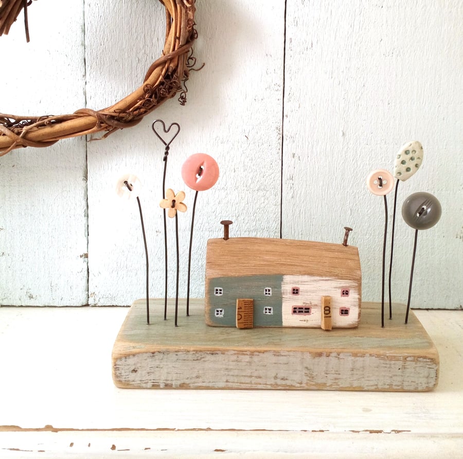 Little wooden painted houses with button flower garden 