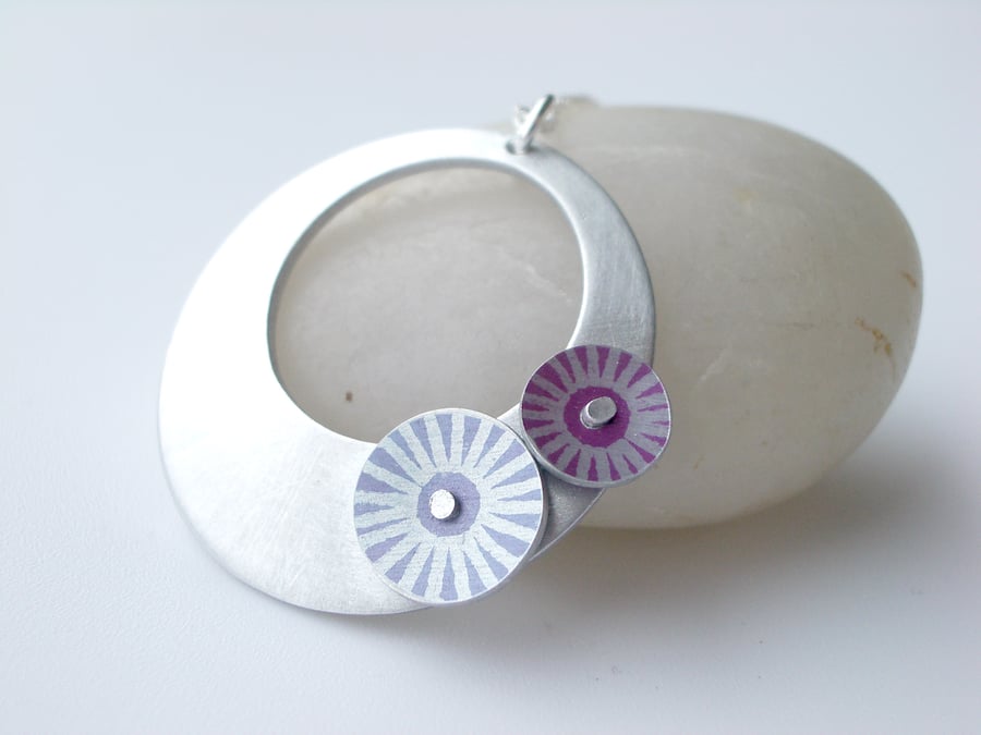 Silver coloured aluminium circle pendant with pink and purple discs