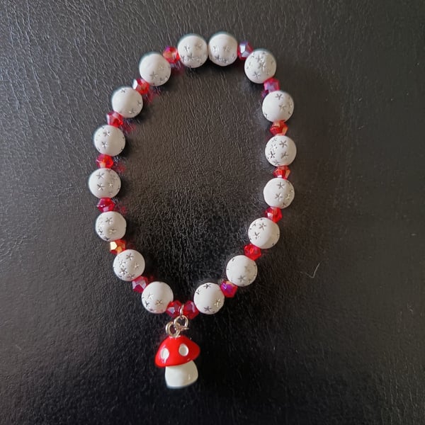 Elasticated cottagecore bracelet with red and white beads and toadstool charm