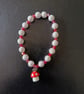 Elasticated cottagecore bracelet with red and white beads and toadstool charm
