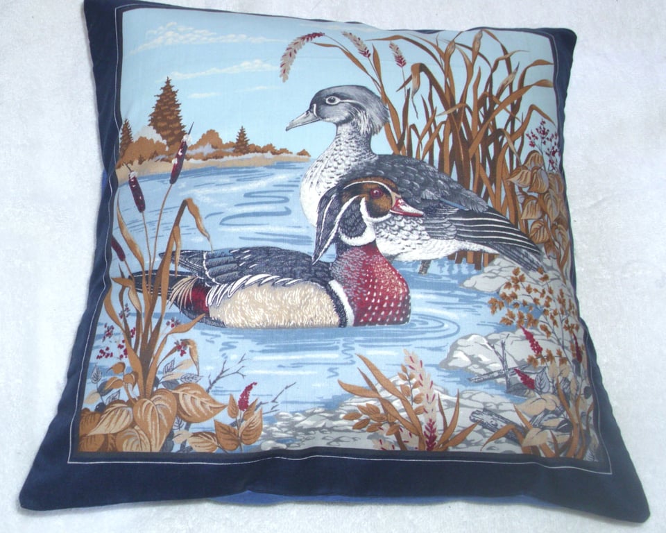 Wood Ducks in the water by a river bank cushion, blue edging