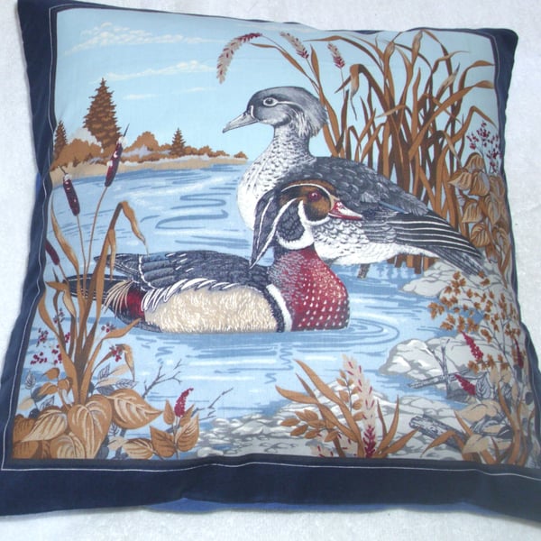 Wood Ducks in the water by a river bank cushion, blue edging