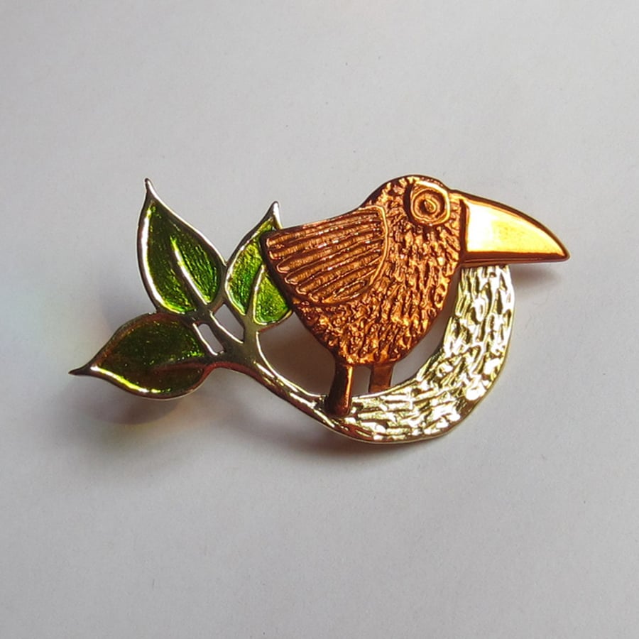 small bird brooch with green leaves