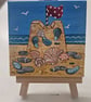 Cute little canvas of a sandcastle on a little easel.