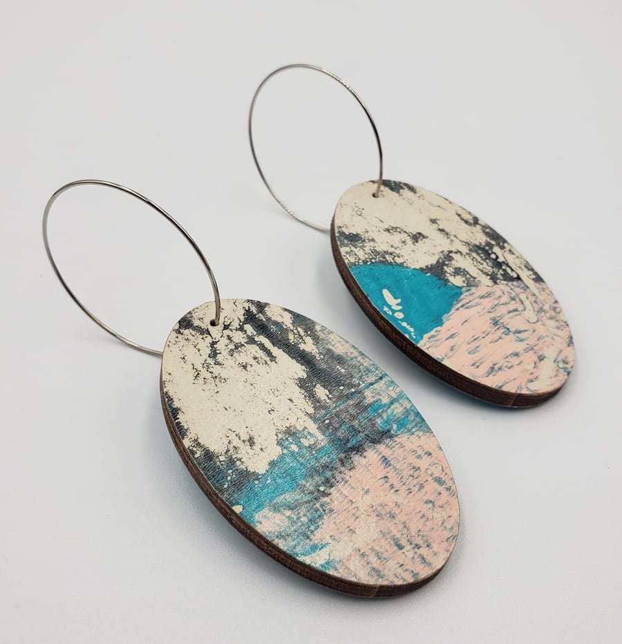 Oval shaped earrings in a watery effect print, blues, white, grey and pink