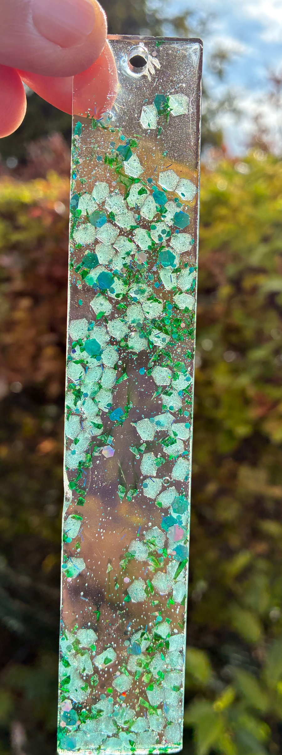 Resin bookmark with green and blue flecks of glitter 