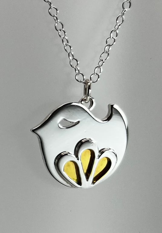 Sterling silver bird pendant with petal embellishment and gold enamel detail