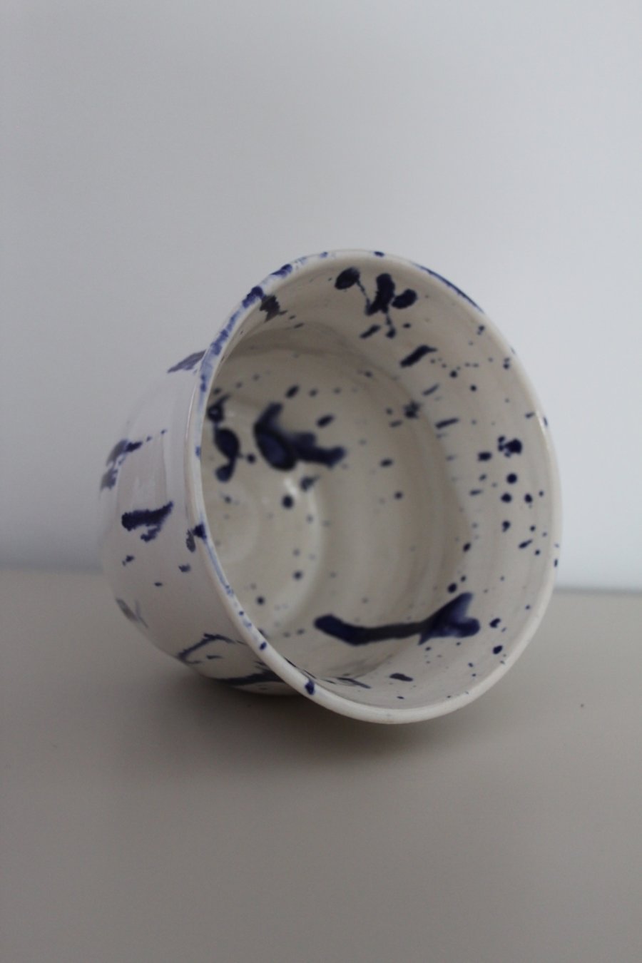 White bowl with blue paint splatter