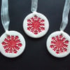 Set of three red snowflakes handmade ceramic decorations