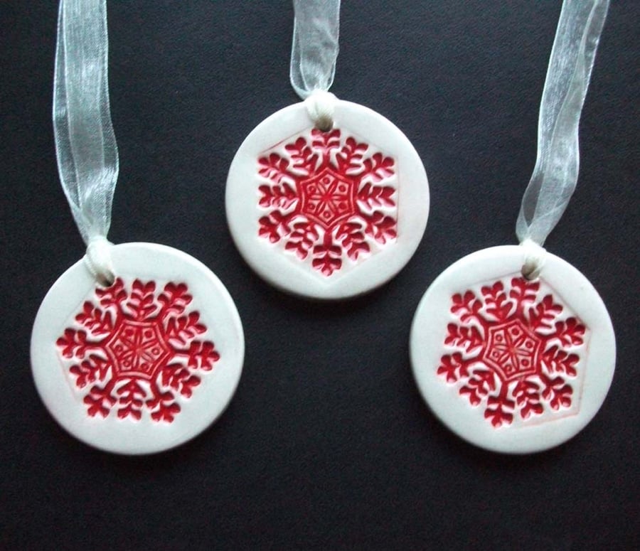 Set of three red snowflakes handmade ceramic decorations