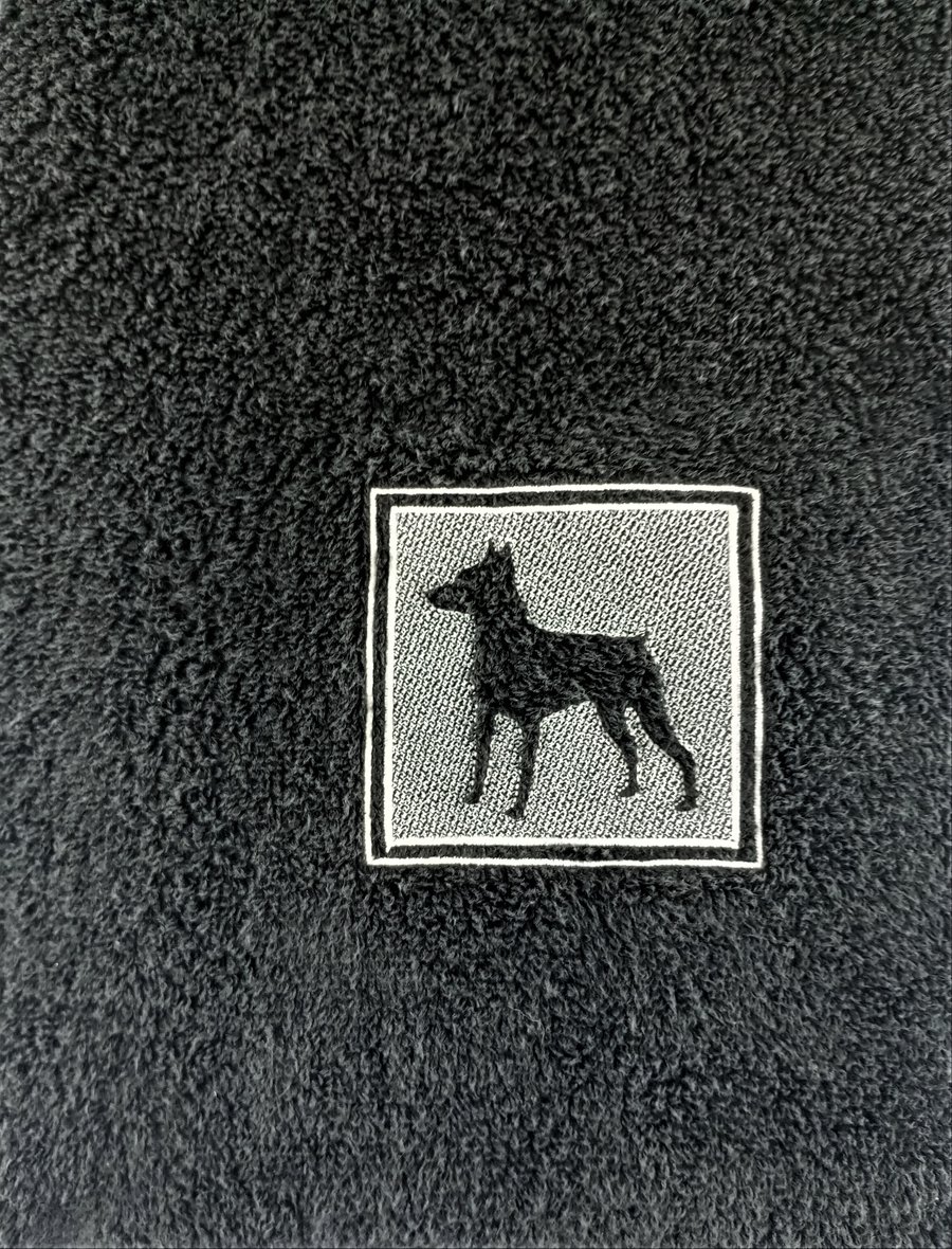 Miniature Pinscher embossed on a black hand towel in cream embroidery thread