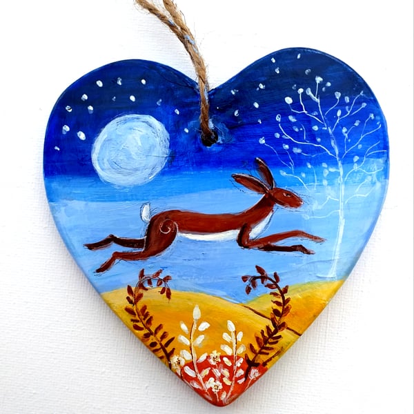 brown hare leaping in moonlight on a ceramic heart 