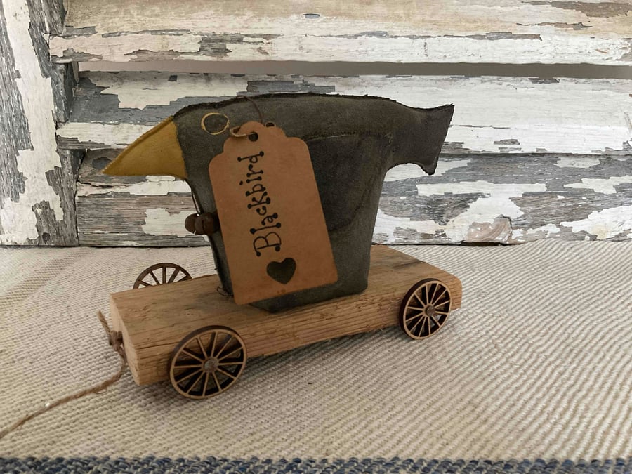 A gorgeous handmade primitive blackbird on wheels