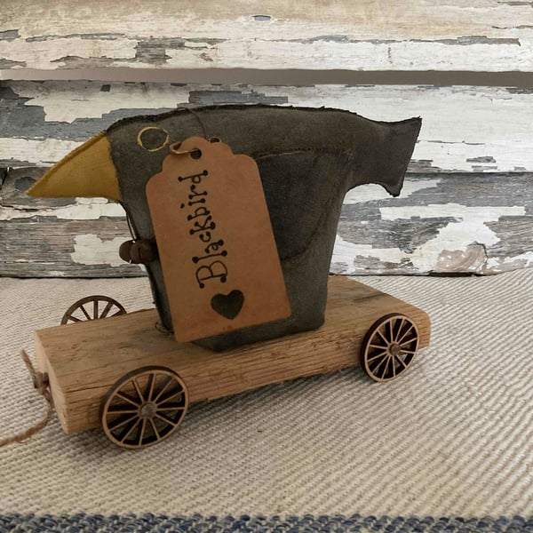 A gorgeous handmade primitive blackbird on wheels
