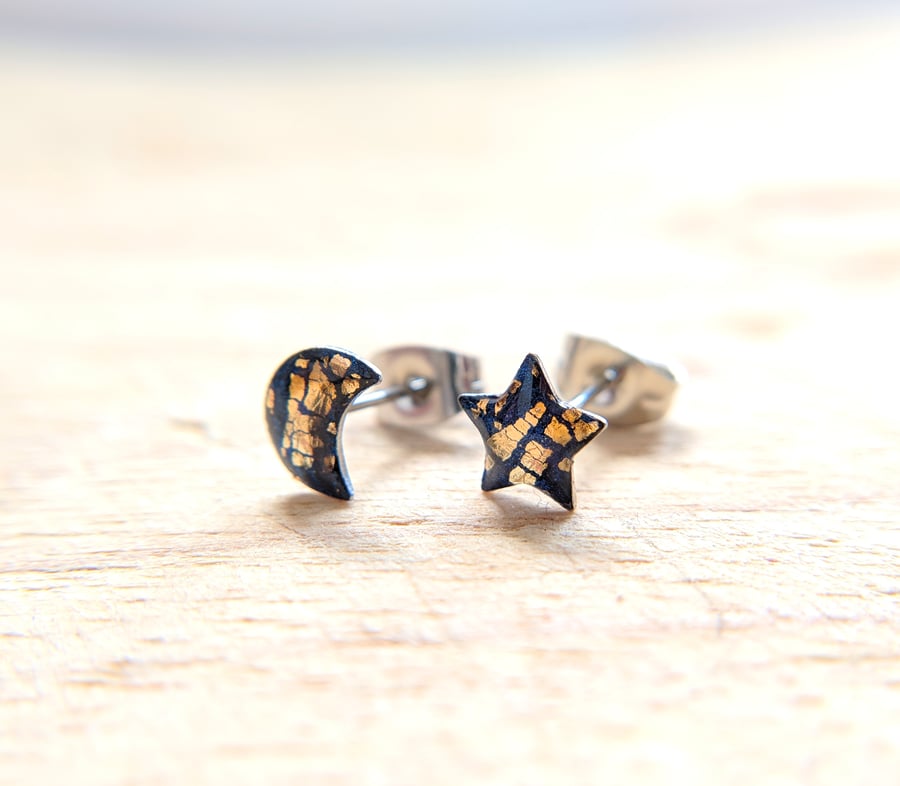 Mismatched moon and star stud earrings in navy blue and gold