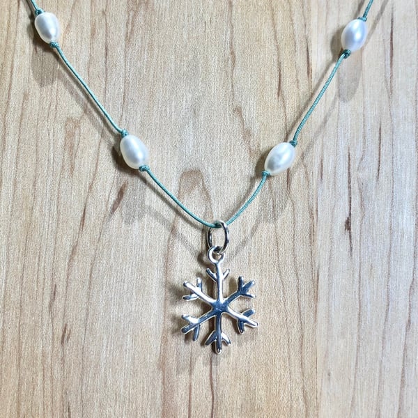 Silver snowflake pendant with freshwater pearls.