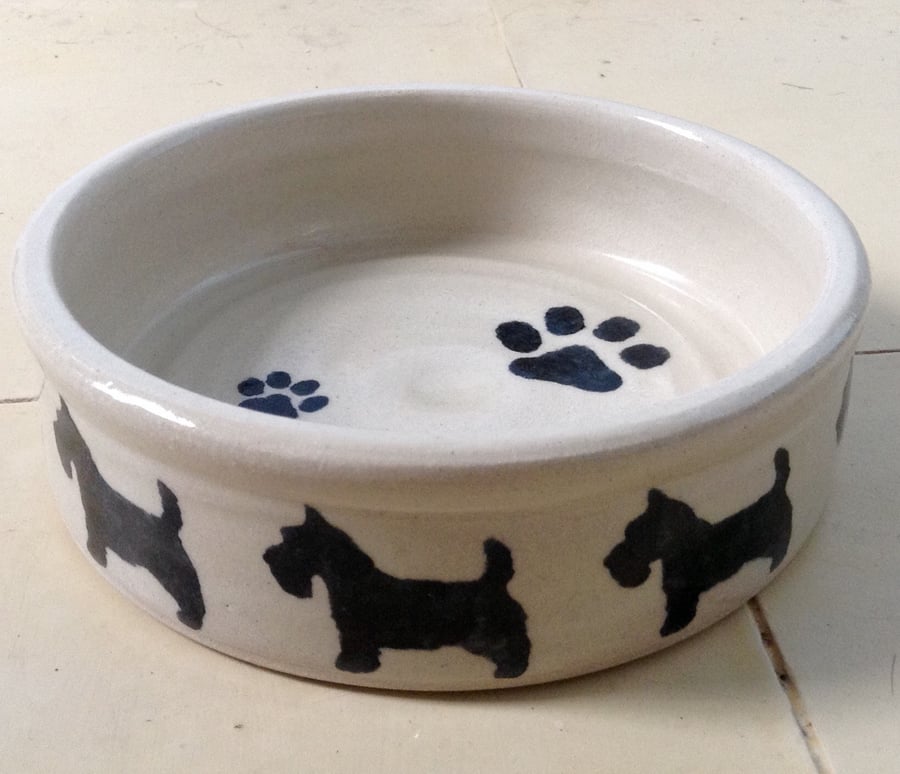 Dog bowl in cream pottery stoneware with scottie dogs design. 