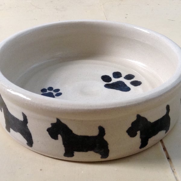 Dog bowl in cream pottery stoneware with scottie dogs design. 
