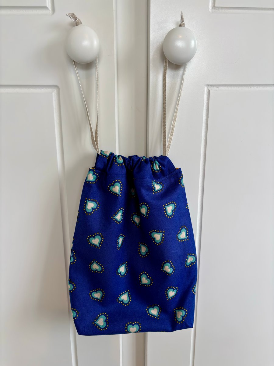 Blue cotton drawstring bag with jade and white hearts, with linen style ribbon.