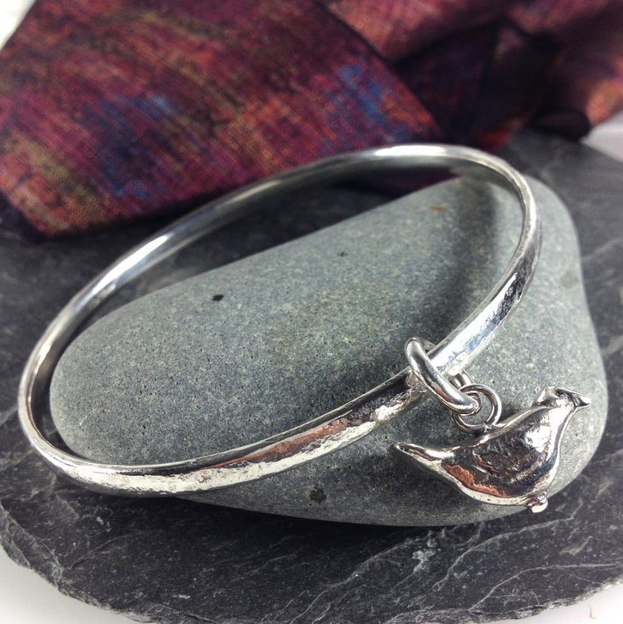 Solid silver round bangle with bird charm.