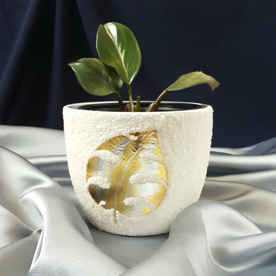 Decorative planter with gold monstera leaf perfect for plantlovers.