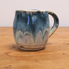 Pottery mug finished in multi-coloured blue and cream glaze, handmade
