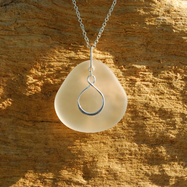 Infinity charm on beach glass pendant