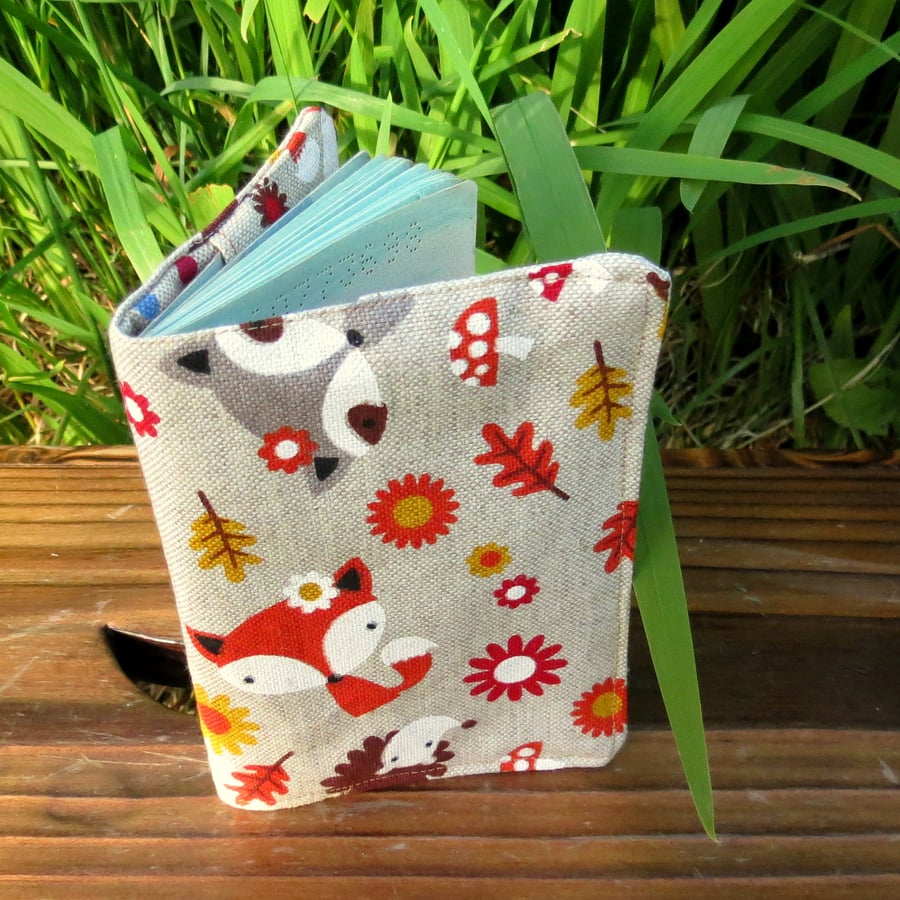 A fabric passport cover with a whimsical woodland design.