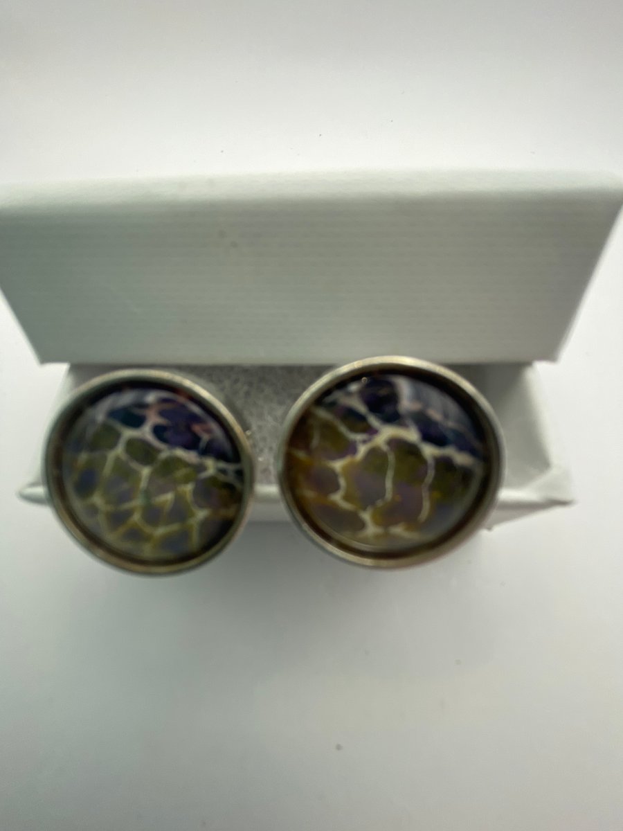 Pair of cuff links with mixed purple and gold and cream pigments 